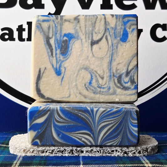 Two marbled soap bars stacked on a stand with a blurred background